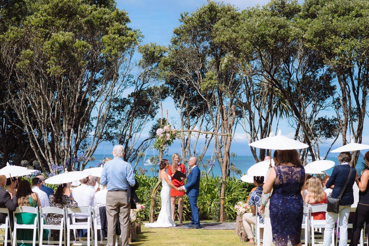 Happy couple exchanging vows with a Waiheke Island ocean view.